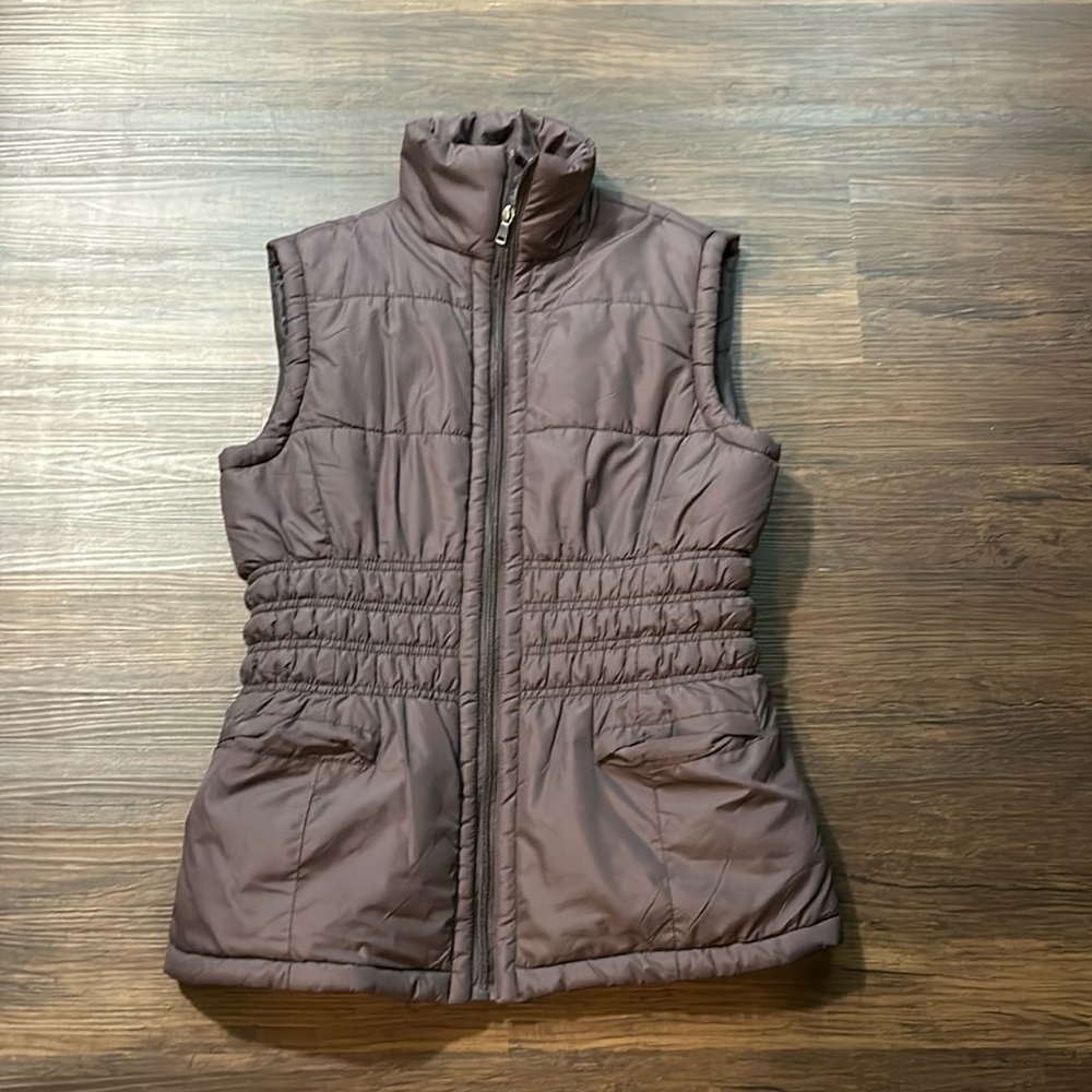 Coffee colored zip up vest with pockets.